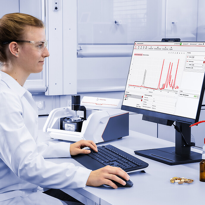 实验人员使用 lyza 3000 ftir 光谱仪分析样品，连接的外部显示器显示出 spectroscopy suite 光谱分析软件