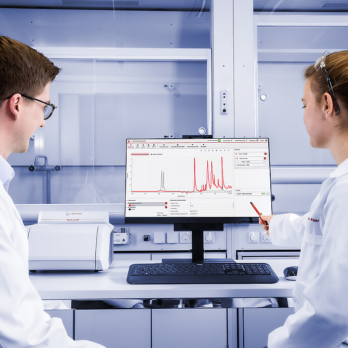 两名实验人员正在操作放置在显示器前的 lyza 3000 ftir 光谱仪，显示器上显示着 spectroscopy suite 光谱分析软件